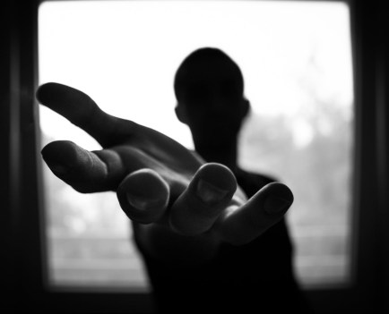 man s hand in shallow focus and grayscale photography